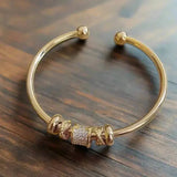 Adjustable bracelet with golden charms